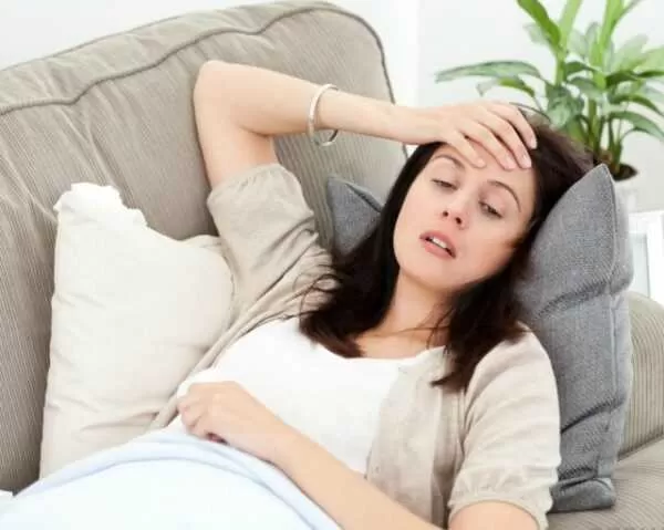 woman-on-gray-couch-looking-nauseous-and-sick.jpg